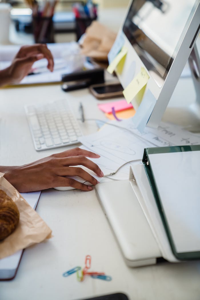 Office setup with person using computer and various desk items, emphasizing a business environment.