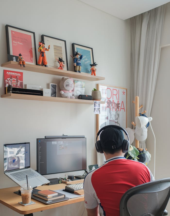 A modern creative workspace with a tech setup, decorated with figurines and art pieces.